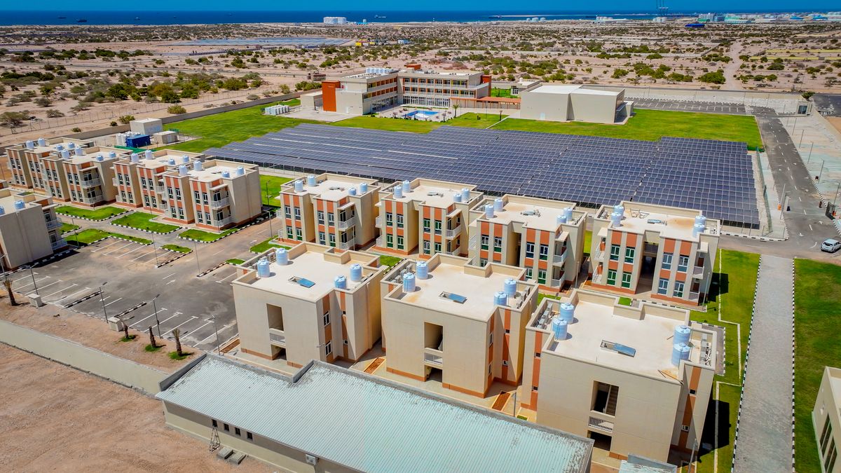 Aerial view of the hotel grounds: villa blocks, gardens, the main building and a large solar panel array