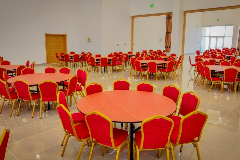 Ballroom set with round tables and red banquet chairs