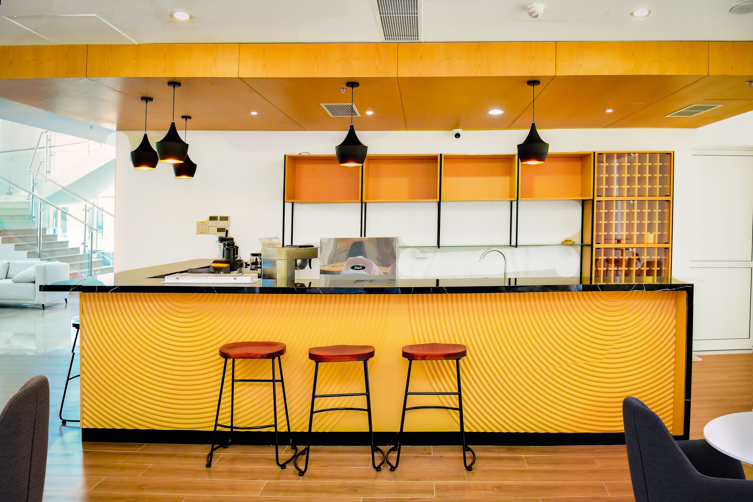 The hotel coffee bar, with amber panelling, pendant lights and bar stools