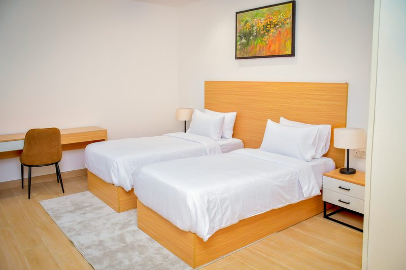 Villa bedroom with a desk and chair, bedside lamps and a painting on the wall